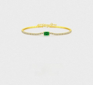 Macro detail of gold bracelet featuring emerald-cut green zircon and pave settings
