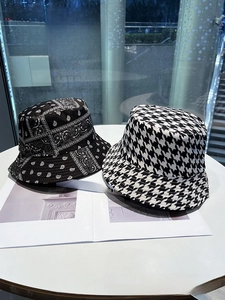 Close-up of reversible bucket hats with paisley floral and houndstooth patterns