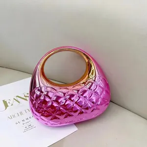 Detail view of pink metallic crossbody bag with diamond quilting and gold circular handle