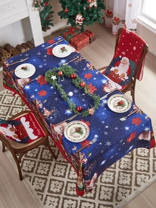 Close-up of blue Santa Claus tablecloth and matching red chair covers for holiday decor