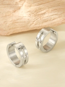 Detail of silver stainless steel hoop earrings with center groove and tiny zircon stones