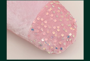Close-up of pink velvet Christmas stocking toe featuring shimmering sequins detail