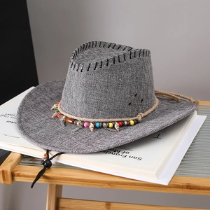 Detail of grey cowboy hat with colorful beads, shells and woven trim for outdoor sun protection