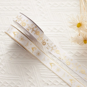 Christmas ribbon rolls with gold reindeer and snowflake patterns for gift wrapping
