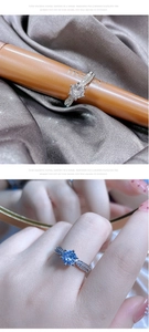 Detail view of silver heart ring with six-claw moissanite setting and side accent stones