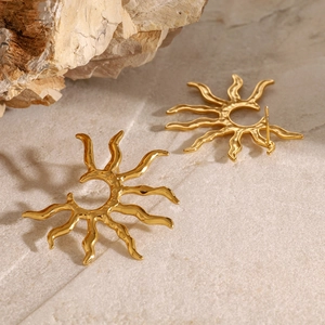 Elegant gold sunflower stud earrings in stainless steel on a natural rock background