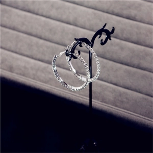 Macro shot of silver oversized hoop earrings with sparkling clear crystals in detail
