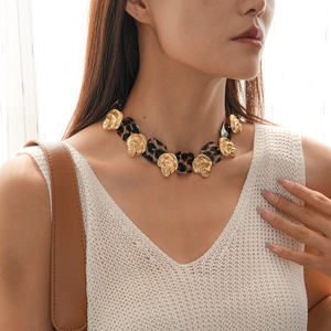 Detail of leopard print resin pieces and golden shell-shaped metal charms on a necklace