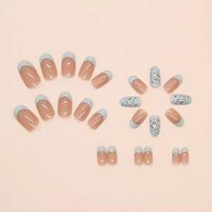 Detail of French press-on nails with blue tips and black quail egg pattern design