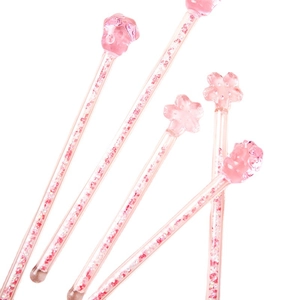Pink glass stir sticks featuring cherry blossoms and paw shapes with glitter inside
