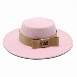 Detailansicht eines rosa Wollfilzhutes mit goldenem Band und M-Buchstaben-Schleife