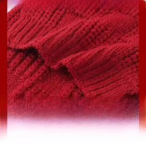 Detail of red cable knit scarf showing thick warm texture and intricate weave patterns