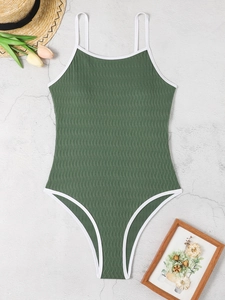 Flat lay of olive green one-piece swimsuit with white trim and ribbed wavy texture