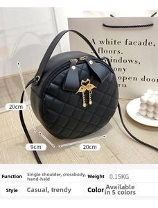 Close-up of black quilted round crossbody bag with swan charm and bow detail