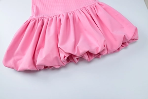 Détail de l'ourlet à volants rose et de la maille côtelée sur cette robe courte moulante