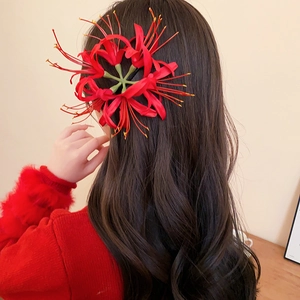 Detailed close-up of a vibrant red Lycoris hair clip worn on long dark wavy hair