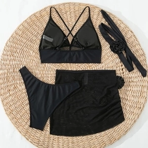 Schwarzes 4er-Set Bikini mit hoher Taille und Netzrock auf Strohmatte präsentiert