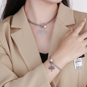 Detail of silver tree of life pendant with pearls and T-bar clasp on double layered chain