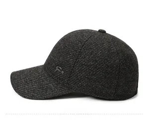 Side view of dark gray knit winter baseball cap with fleece lining and metal logo detail