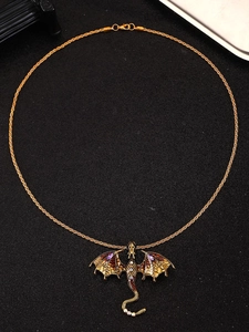 Detailed view of vintage flying dragon pendant with purple gems on gold rope chain