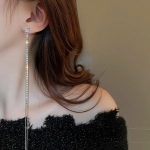 Detail of long silver tassel earrings with zircons shown on a model for elegant styling