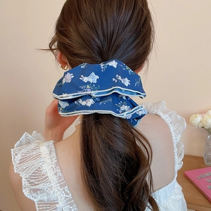 Detail view of floral scrunchie with rabbit patterns and white wavy edge on hair