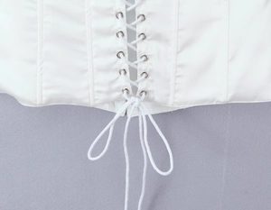 Détails du haut corset en satin blanc avec laçage et œillets métalliques