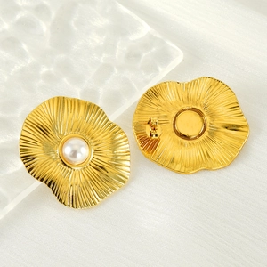 Vintage gold lotus leaf pearl earrings in stainless steel on white satin background