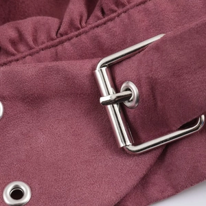 Détail du tissu suédine bordeaux avec boucle en métal argenté et œillets métalliques