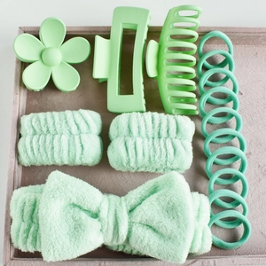 Detailed set of mint green bow headband, hair claws and wristbands on a tray