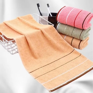 Detail of absorbent cotton towels with striped texture in orange, pink and gray tones