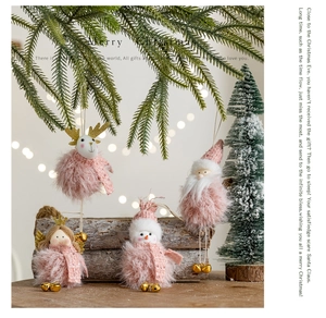 Pink plush Christmas dolls including Santa and elk on wooden and pine branch background