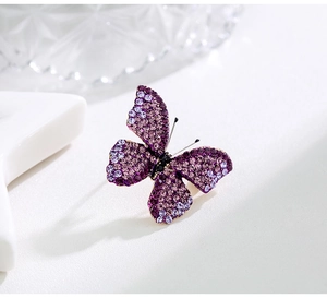 Close-up of butterfly brooch with purple rhinestones and micro-pave crystals