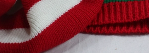 Close-up of red and white striped knit fabric showing texture and ribbed cuff detail