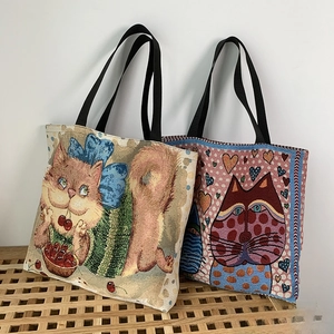 Detailed view of woven jacquard tote bags with cute cat patterns and black handles