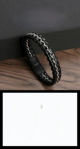 Detail of hand-woven leather and stainless steel bracelet with magnetic clasp on wood
