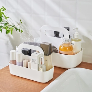 Gros plan d'un panier de douche en plastique blanc avec poignée sur un plan de toilette