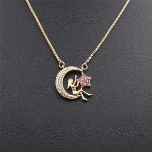 Détail du pendentif lune et fée doré orné de cristaux rouges et blancs brillants