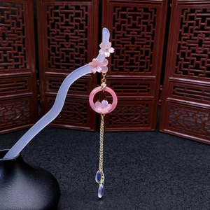 Classical acetate hair stick with pink cherry blossoms and gold tassels on a stand