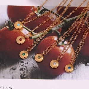 Detail of 18K gold plated necklaces featuring circular birthstone pendants in vibrant colors