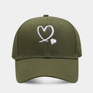 Detailed view of the dark green cotton fabric and white heart embroidery on the baseball cap
