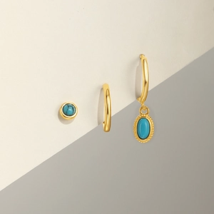 Detail of s925 silver turquoise bow earrings set with gold plating and polished finish
