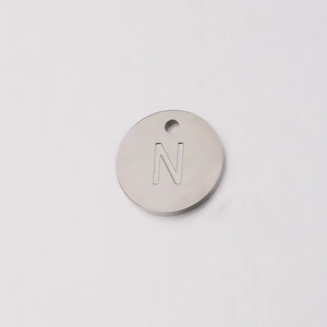 Macro shot of 12mm stainless steel round charm with engraved letter N detail