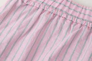 Détail du tissu en coton à rayures roses et grises avec texture élastique plissée