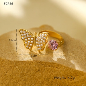 Detail of gold double-layer butterfly ring with pearls and pink crystal stone