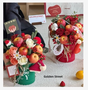 Detailed Christmas flower bucket with apples and roses in red and green festive boxes
