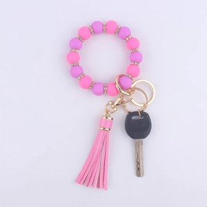 Detail of pink and purple beaded bracelet keychain with rhinestones and tassel