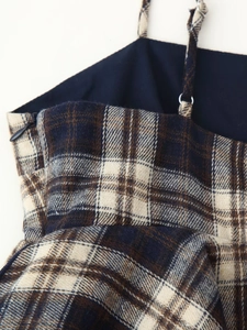 Detailed macro view of the textured plaid fabric and invisible side zipper on the top