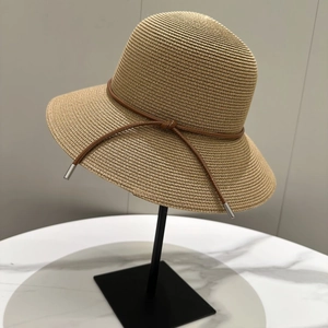 Chapeau de soleil beige à large bord avec cordon en cuir marron et détails argentés