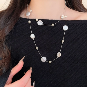 Detail of double-layer French vintage pearl necklace with baroque crystals on dark knitwear